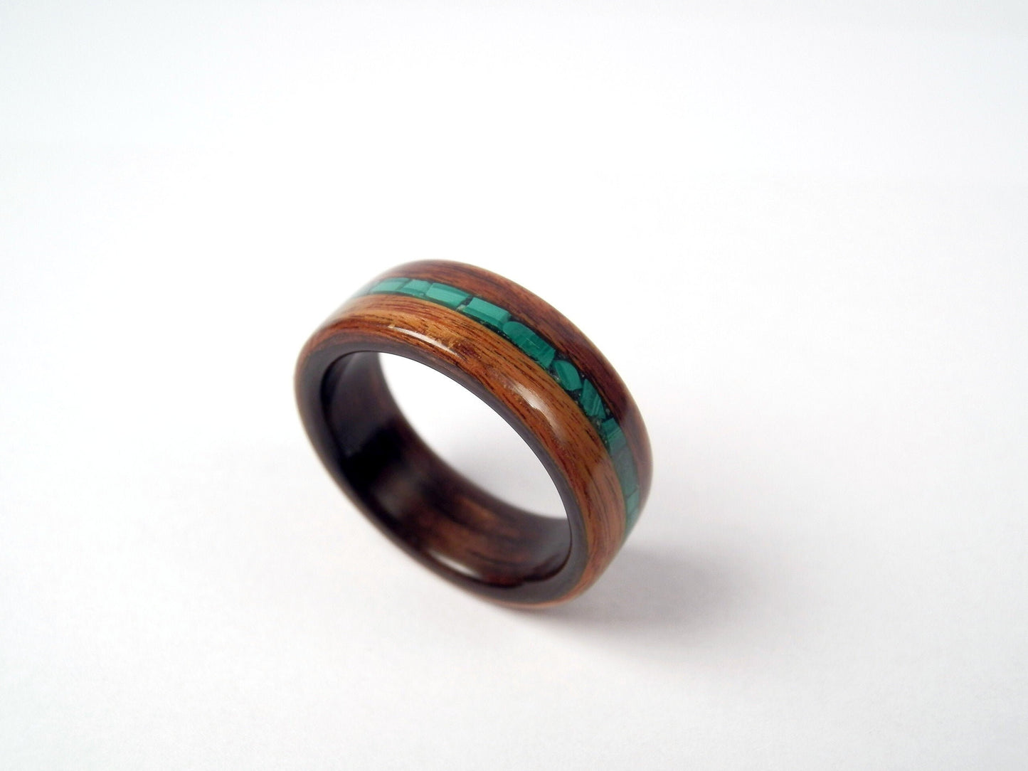 A palisander ring band with a polished dark brown wood grain and a vibrant green malachite inlay, shown on a clean white background.