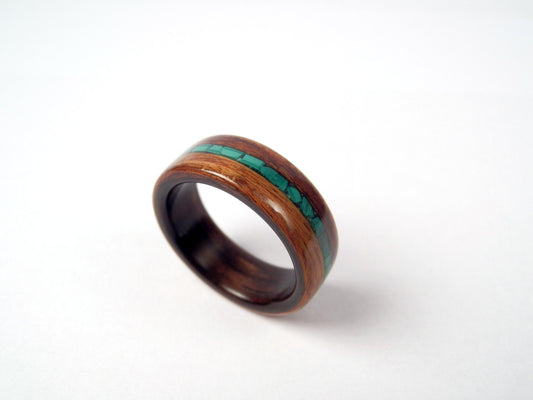 A palisander ring band with a polished dark brown wood grain and a vibrant green malachite inlay, shown on a clean white background.
