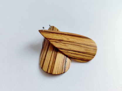 A pair of wooden dangle earrings with a natural striped grain pattern, shown on a plain light gray background.