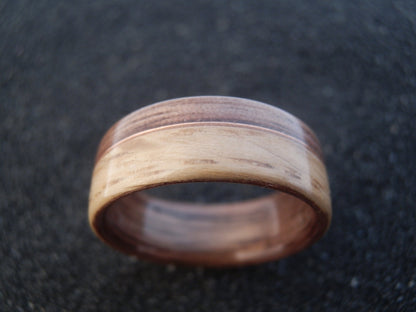 A dark walnut and oak bentwood ring with copper wire inlay